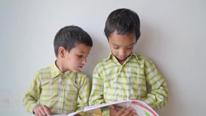 两个可爱的小农村小学生手里拿着书，在教室里看书。