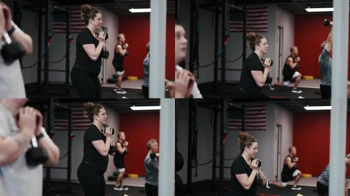 在集体健身课上用哑铃重量锻炼的女人
