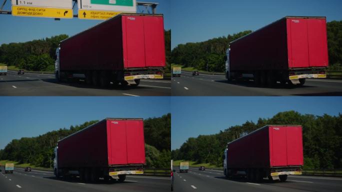 带货运拖车的半卡车驶过高速公路。卡车是白色的，货物拖车是红色的。在黑魔法袖珍电影摄像机6K上拍摄