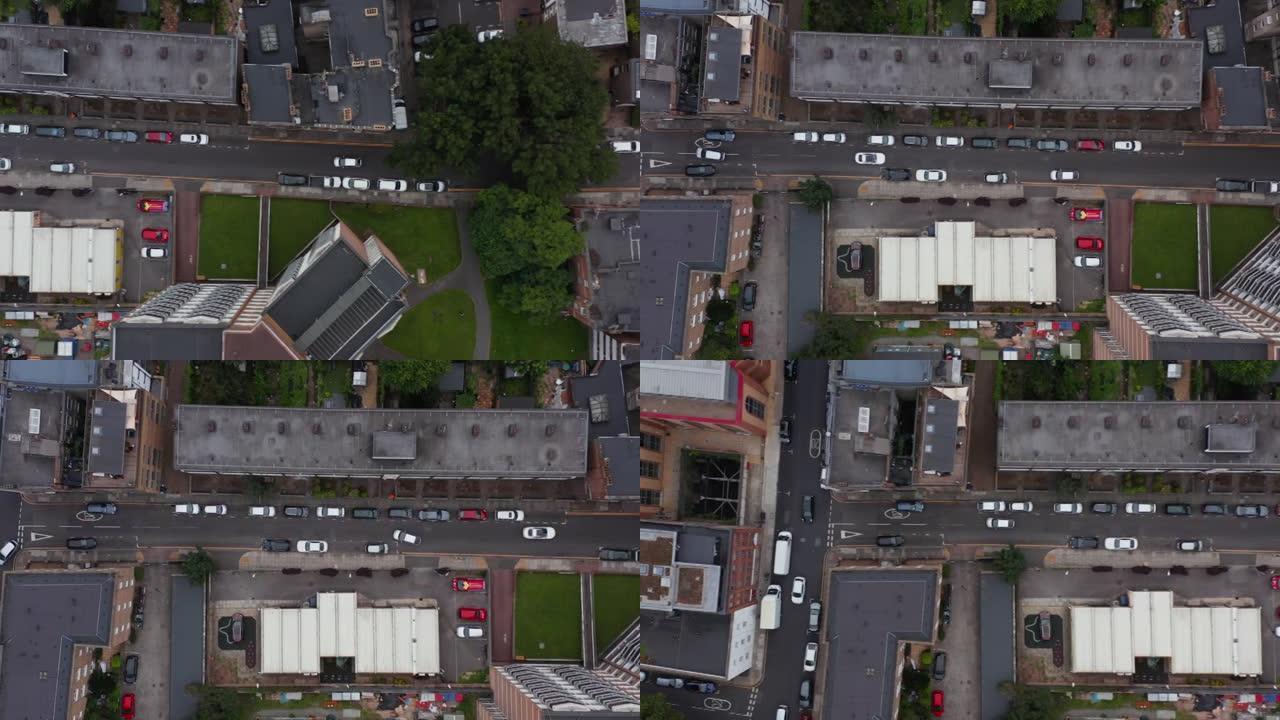 空中鸟瞰头顶向下跟踪汽车的视图让位于狭窄的城镇街道上迎面而来的交通。英国伦敦