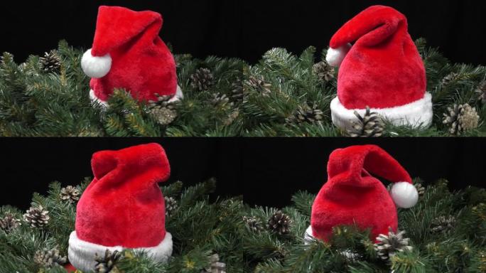 红色圣诞老人帽子被绿色圣诞树树枝和运动中的锥体包围