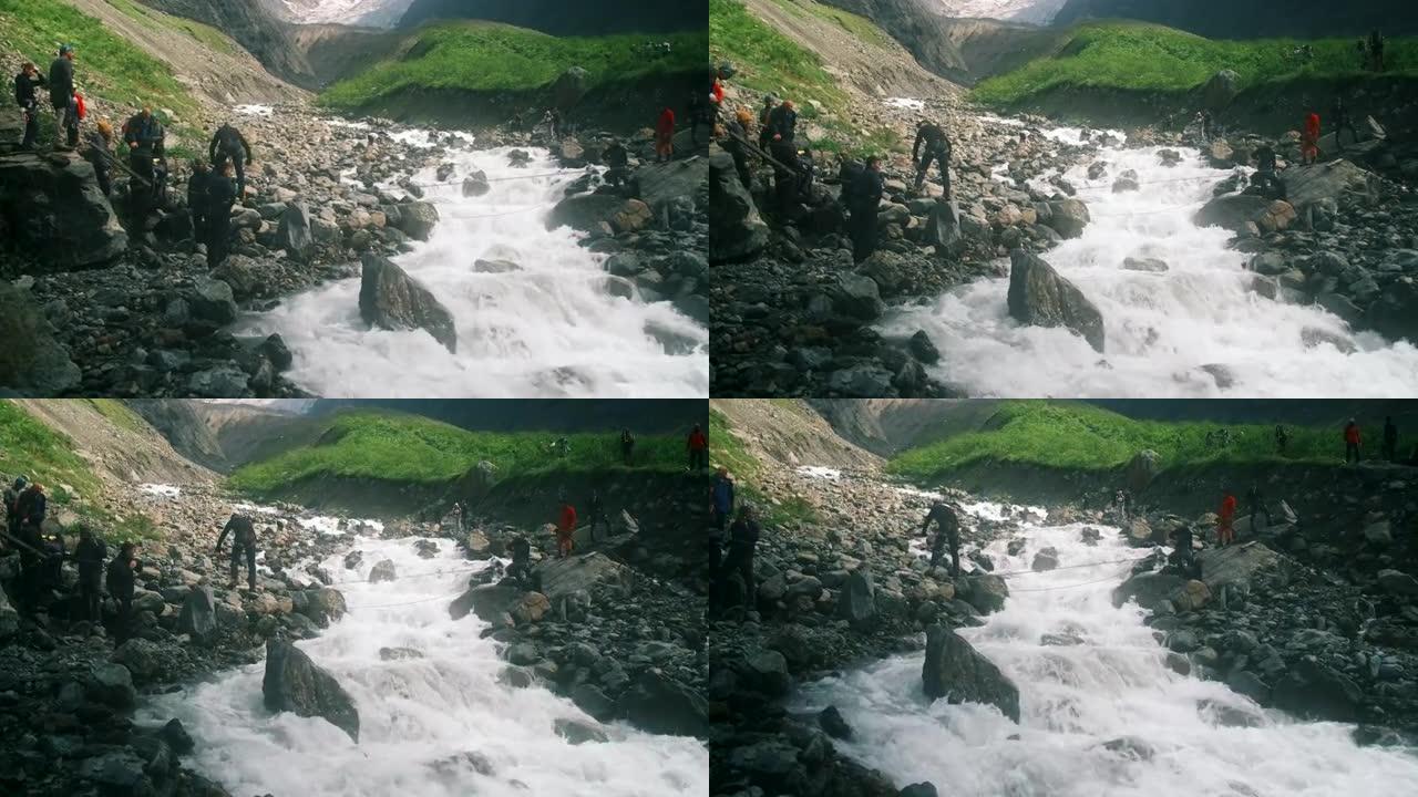 一位游客过河到对岸，用登山扣固定在绳子上。