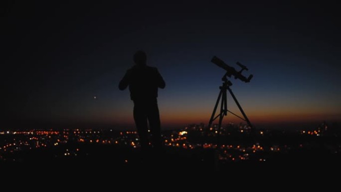 星空下的男人，望远镜和城市路灯的轮廓。