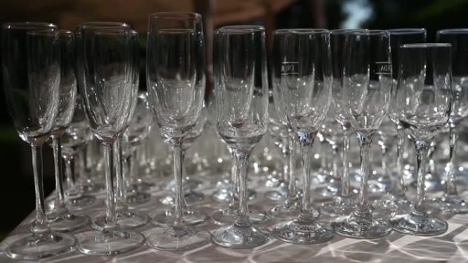 一排水晶葡萄酒和香槟酒杯站在宴会桌上