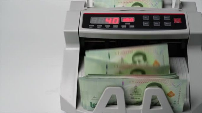 慢动作特写拍摄泰国钞票20泰铢在点钞机，货币，计数，银行柜台，机械，纸币，金融市场概念