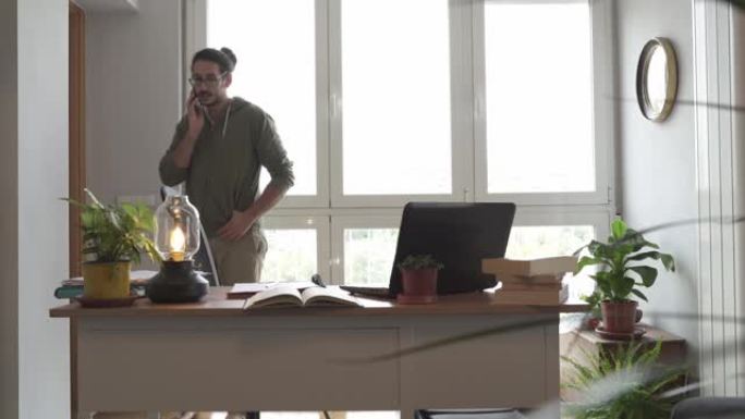 站在办公桌旁在家工作的男性开始在电话里生气