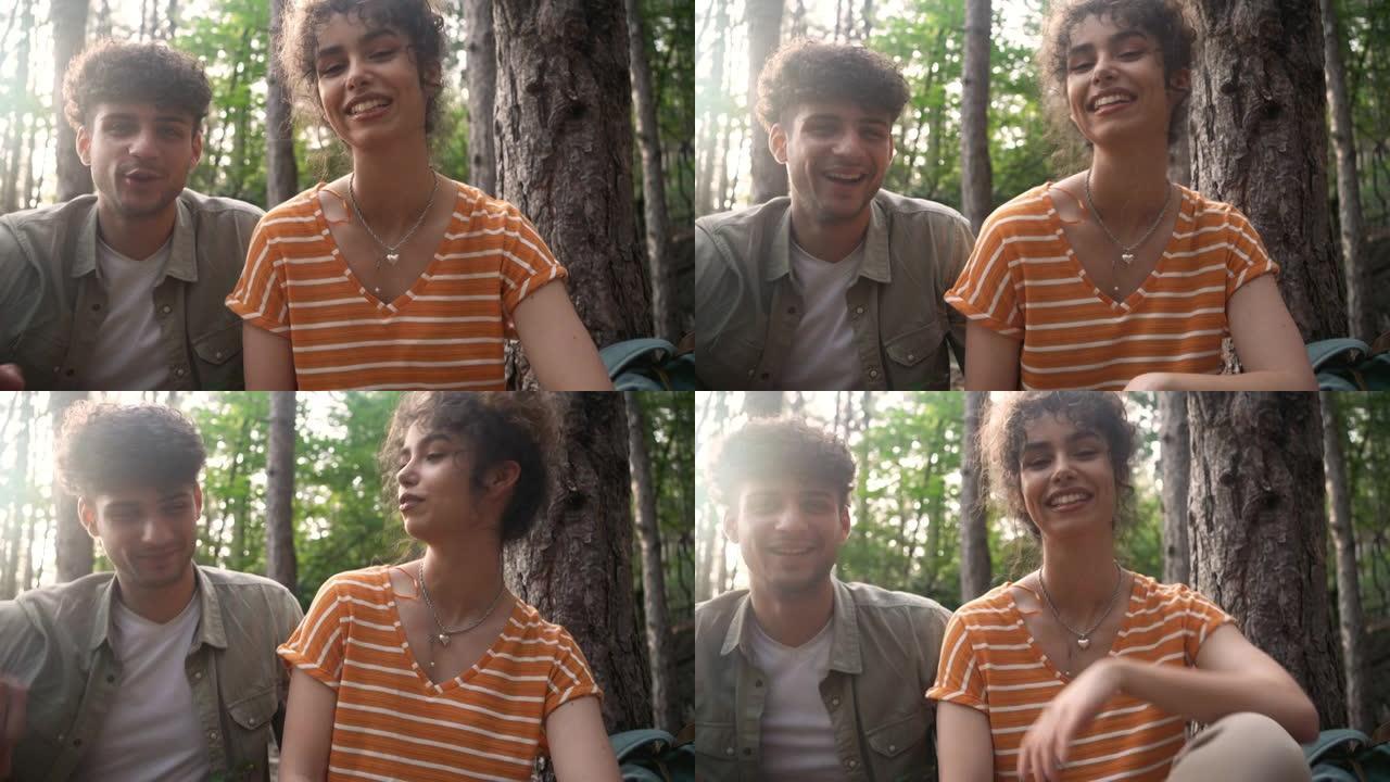 年轻夫妇在树林里休息，并为他们的vlog录制视频