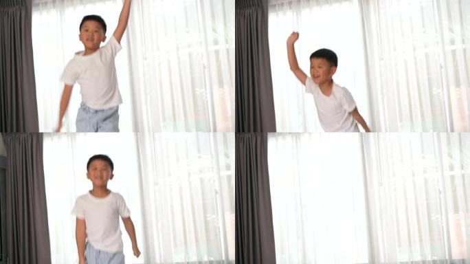 亚洲孩子在酒店的卧室里跳和听音乐。旅游和度假的概念