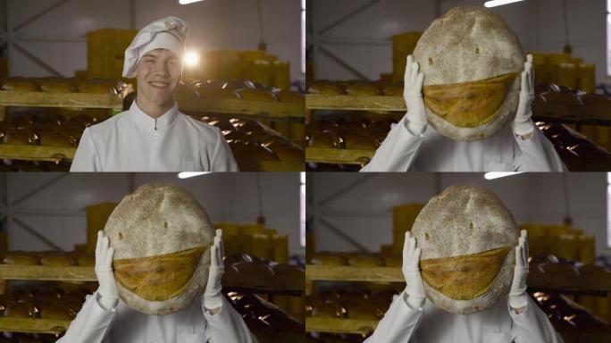 穿着制服的面包师举起了一条大面包，脸上露出微笑的表情