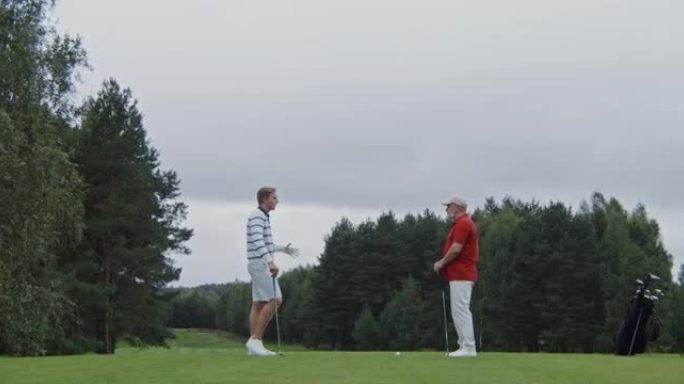 两个穿着时髦的男人，年龄差距很大，一起聊天和打高尔夫球