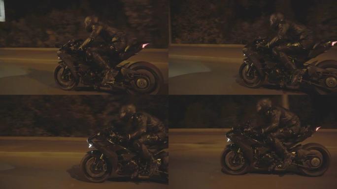摩托车手在夜路骑着强大的运动摩托车。在夜间城市街道上，穿着摩托车防护装备的男性骑自行车的人驾驶现代摩
