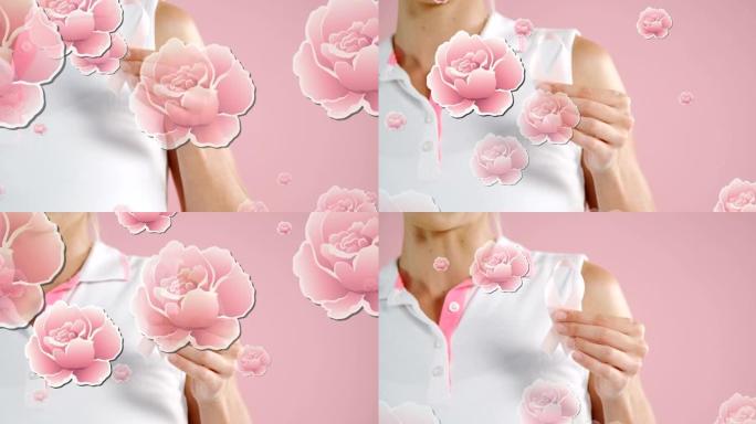 粉红玫瑰漂浮在手持乳腺癌丝带的女人的手上，在粉红色