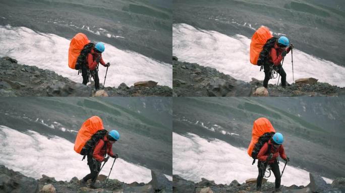 山里的一名妇女带着一个装有装备和登山杖的大背包爬上去。