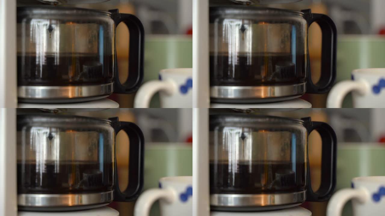 家用咖啡机中的咖啡在家庭烹饪的背景下滴落。