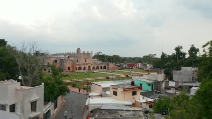 向前飞过镇上的街道。揭示圣贝纳迪诺·德锡耶纳修道院的公园和旧砖砌建筑。历史地标。墨西哥巴利亚多利德