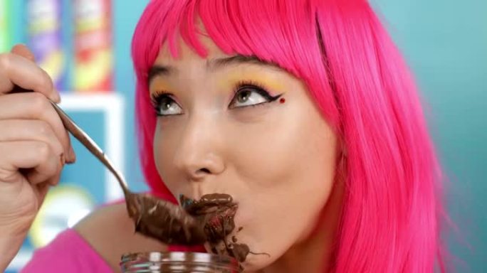 肮脏的女孩用勺子吃巧克力。
