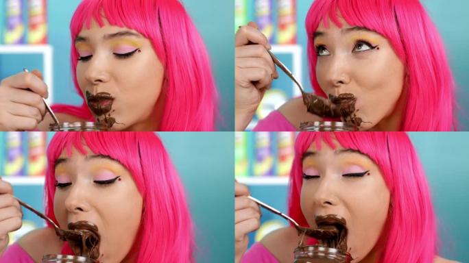 肮脏的女孩用勺子吃巧克力。