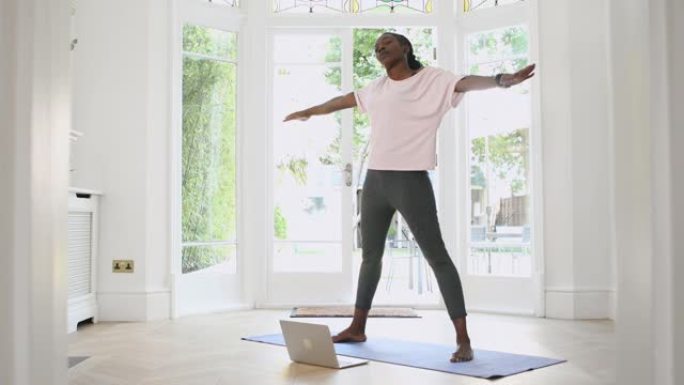 一个活跃的退休黑人妇女在家上在线瑜伽课