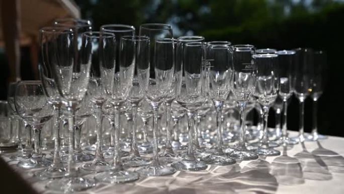 一排水晶葡萄酒和香槟酒杯站在宴会桌上