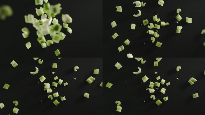 慢动作: 新鲜的绿色芹菜片掉落在黑色表面上