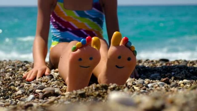孩子的脚在海滩上画了一个微笑。选择性聚焦。孩子。
