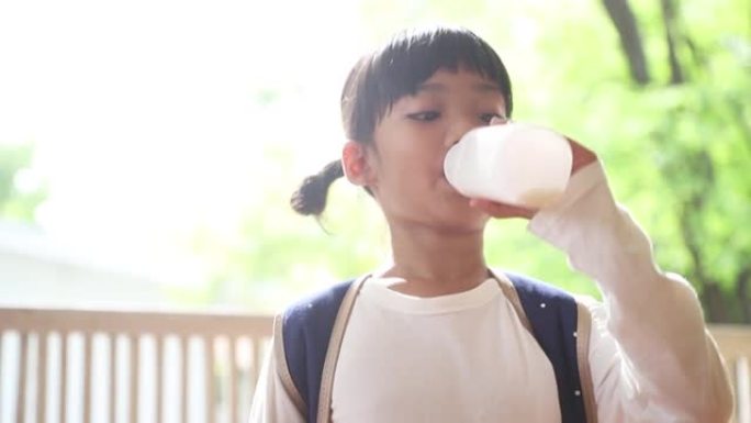 可爱的亚洲小女孩正在喝牛奶