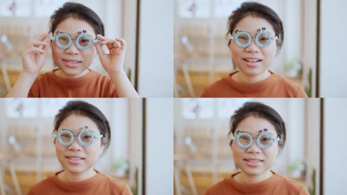 眼科医生用验光师试验框架检查有吸引力的亚洲女性。亚洲女性患者在眼科诊所检查视力光学商店背景