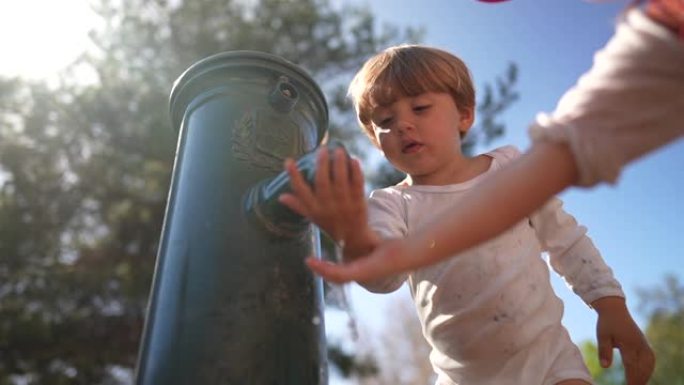 儿童在公园的水龙头中以慢动作喝水