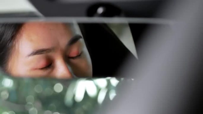 从后视镜上看到压力重重的女人和疲惫的疲惫在车里哭泣。过度劳累的司机概念。