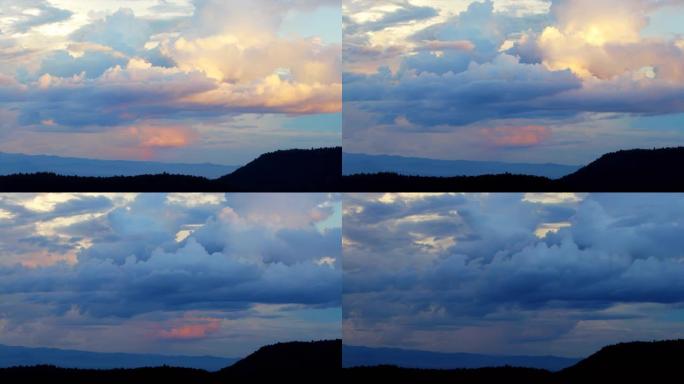 日落时分，神奇的蓝色和橙色的云朵在山上盘旋。延时，放松天气戏剧性的美丽氛围背景