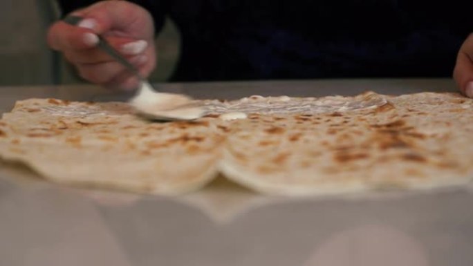 桌子上的特写镜头是玉米饼，在制造自制的沙瓦玛时，玉米饼充满了一个女人的填充物