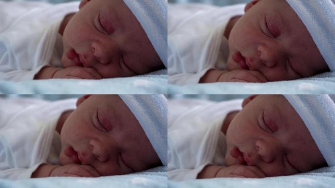 初生婴儿脸部肖像的特写镜头早期在蓝星背景下睡觉。孩子在帽子上生命的开始。婴儿，分娩，出生的最初时刻，