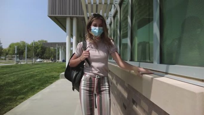 十几岁的女性戴着口罩在公立学校大楼外行走，要求遵守学校4k视频系列