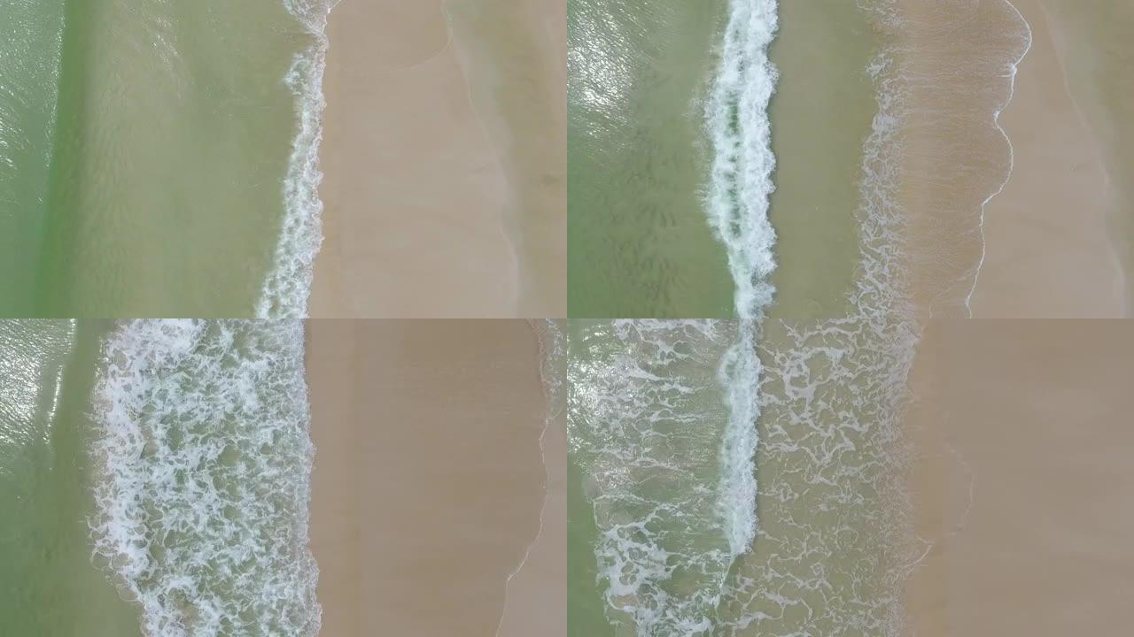 在沙质海岸线上破碎的turquiose海浪的俯视图