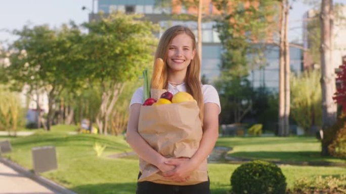 购物后，快乐而令人兴奋的漂亮女士在街中央拿着装满食物的生态袋摆在镜头前
