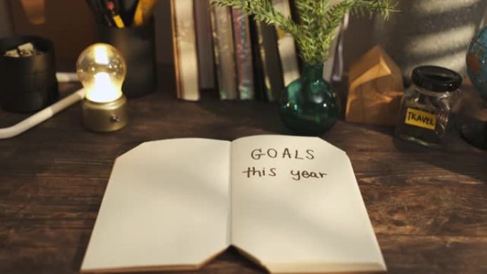 今年的目标是在家里的木头桌子上的笔记本上手写，早晨从窗户上晒下来。新年决议目标清单