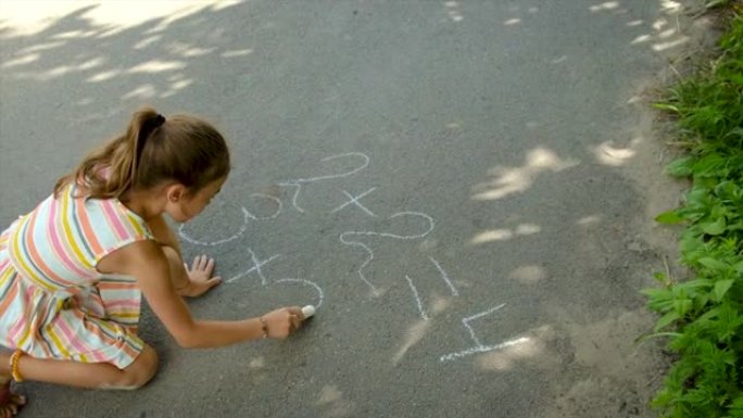 孩子在沥青上写方程式。选择性聚焦。
