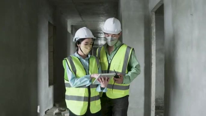 一群穿着反光背心和安全安全帽在施工现场工作的工程师。建筑工程师团队合作的前视图