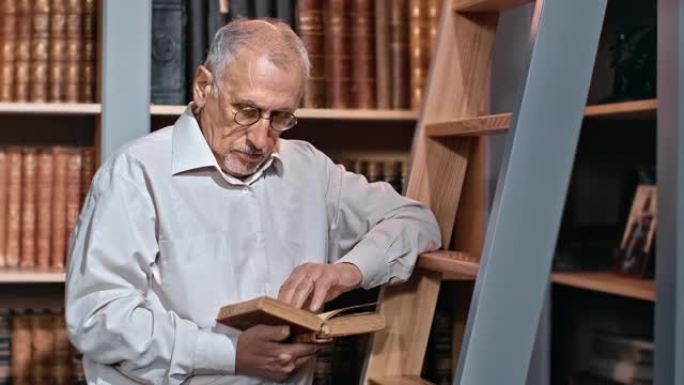70多岁的男性大学教授在公共图书馆阅读图书检索信息讲座