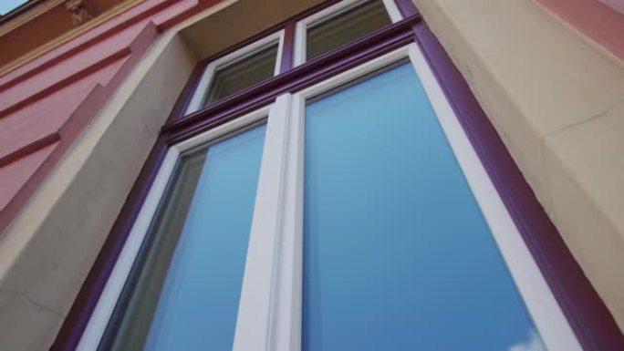 紫色框架窗户的玻璃反映了卢布尔雅那的蓝天