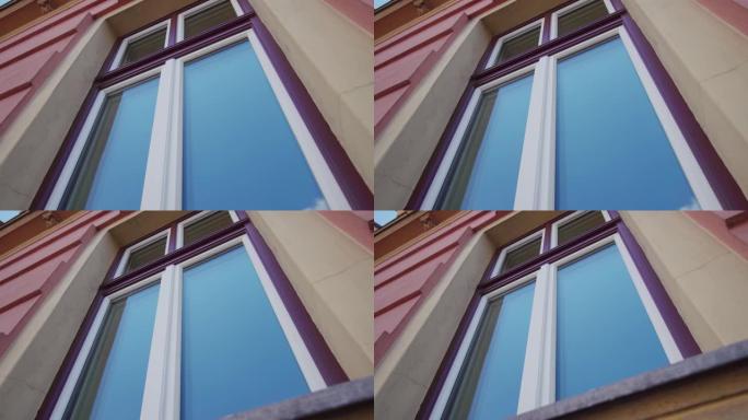 紫色框架窗户的玻璃反映了卢布尔雅那的蓝天