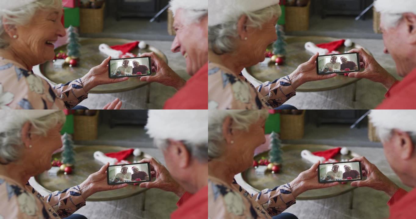 高级高加索夫妇使用智能手机进行圣诞节视频通话，屏幕上有微笑的家人