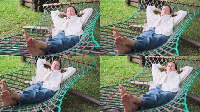 美丽的年轻女子安详地睡在吊床上