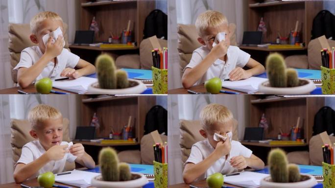 一个小男孩正在做作业，他感冒了，用餐巾纸擦鼻子。