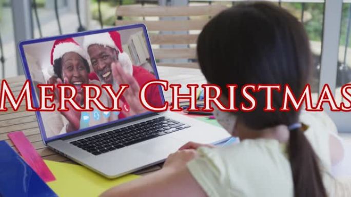 带口罩的女孩在笔记本电脑视频上与家人通话的圣诞快乐文本动画