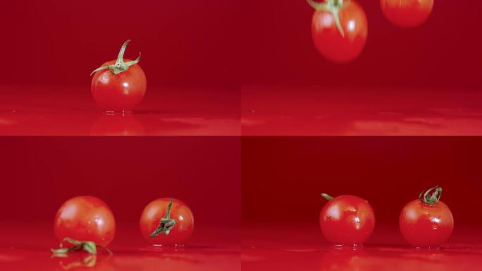 一组红色成熟西红柿的视频镜头，绿色尾巴落在潮湿的反光桌面上。成熟的樱桃在红色工作室背景上泼水击中桌子