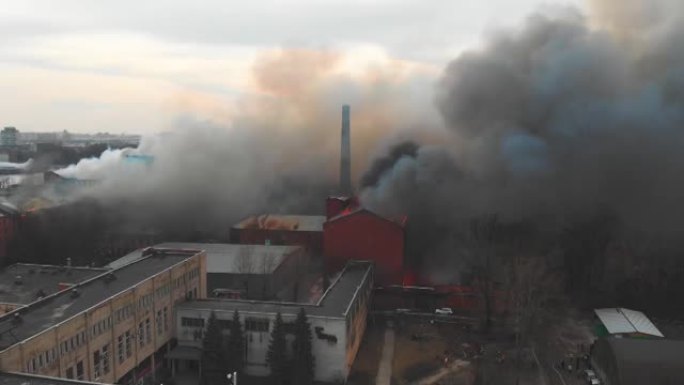 城市发生大规模大火，空中无人机俯视图砖厂大楼着火，地狱火爆炸火焰爆炸，有消防员队伍，纵火，烧毁破坏