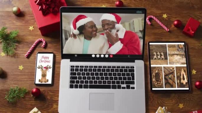 非裔美国高级夫妇在笔记本电脑上进行视频通话，配备智能手机，平板电脑和装饰品