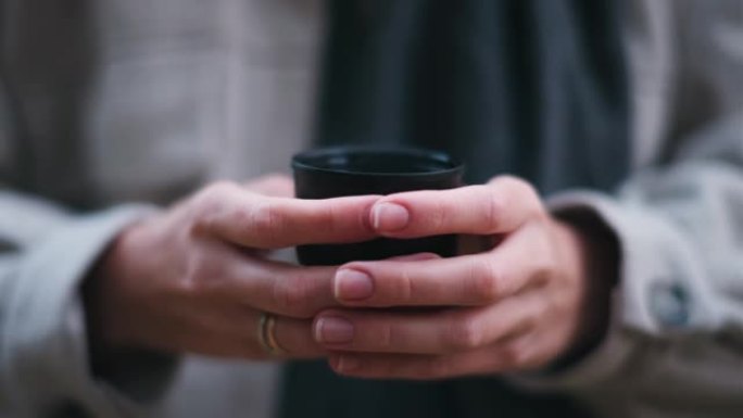 女人在森林里拿着保温杯喝茶