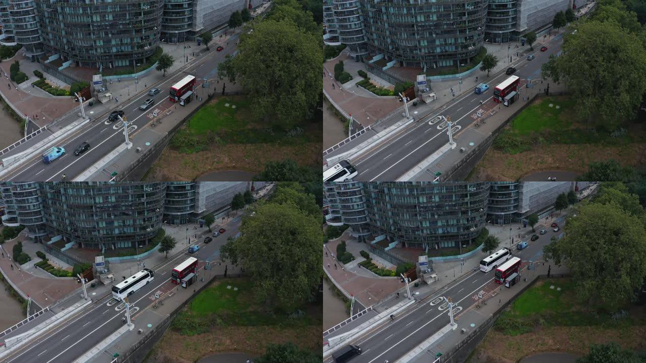 现代住宅区道路鸟瞰图。圆形公寓大楼。红色双层站在公共汽车站。英国伦敦